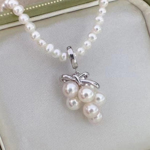 A sterling silver grape-shaped pendant with a chain of pearls attached to it.